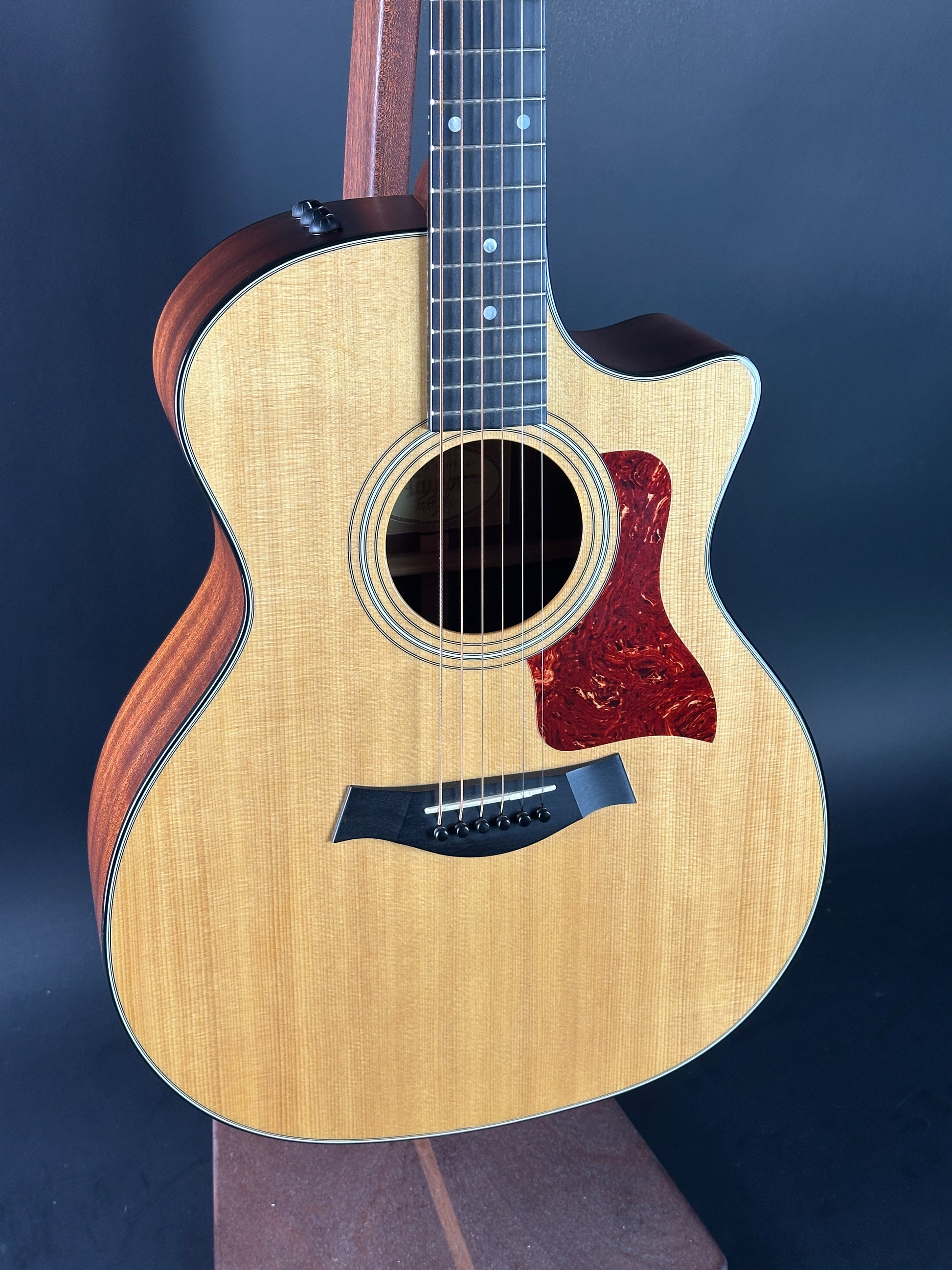 Acoustic guitar with a cutaway design on a dark background