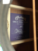 Close-up of a guitar label with 'Martin & Co.' branding on a wooden background.