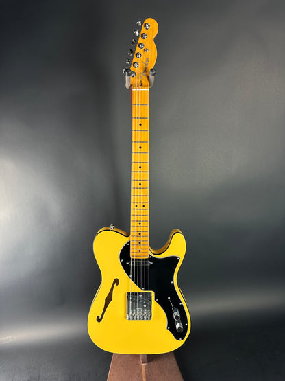 Yellow electric guitar on a dark gray background