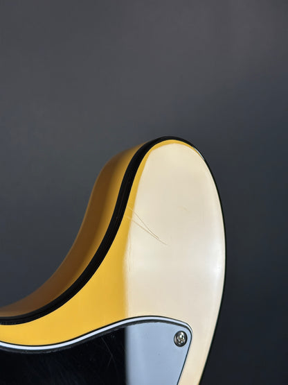 Close-up of a guitar neck with a dark background