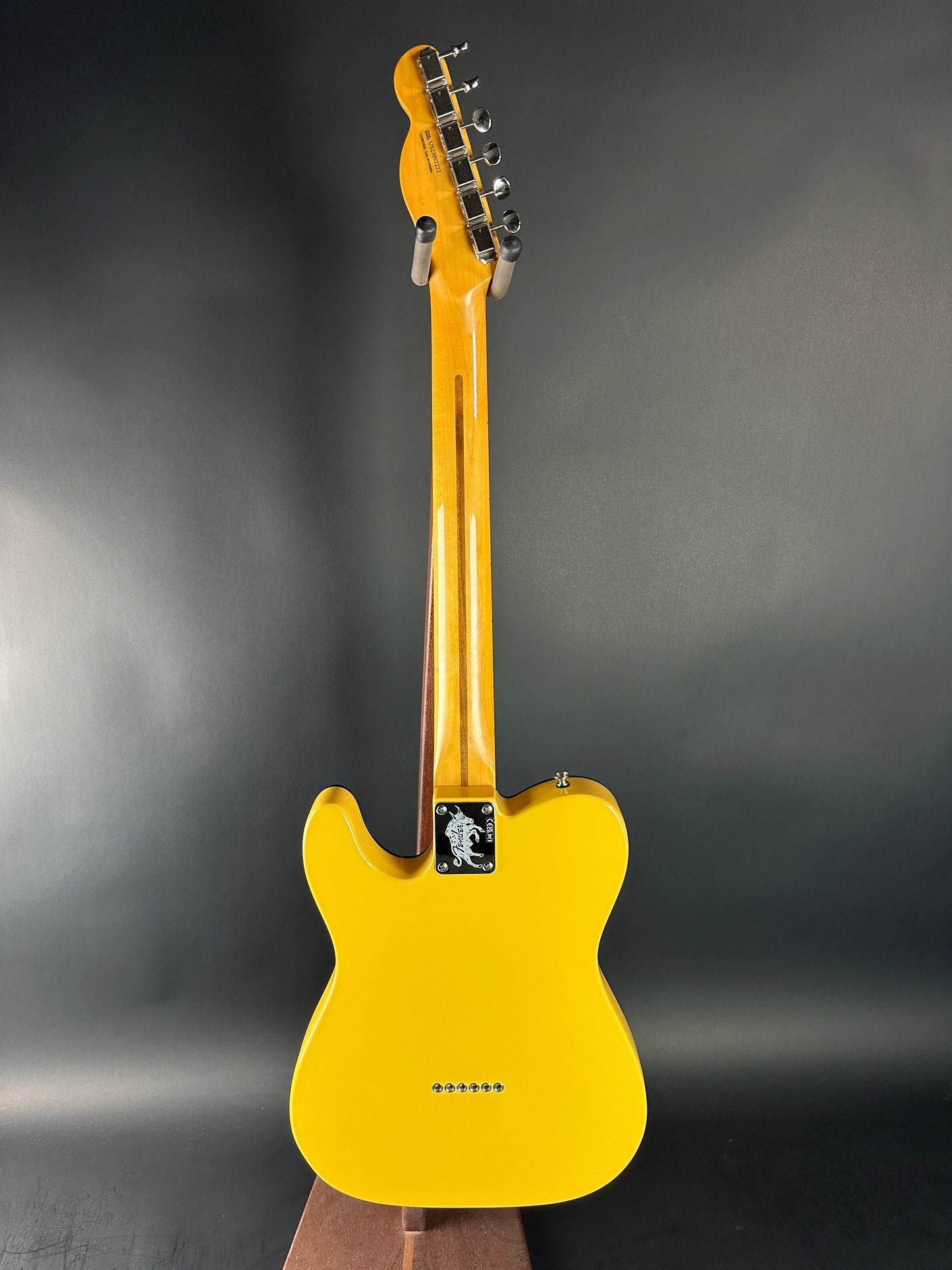 Yellow electric guitar on a dark gray background