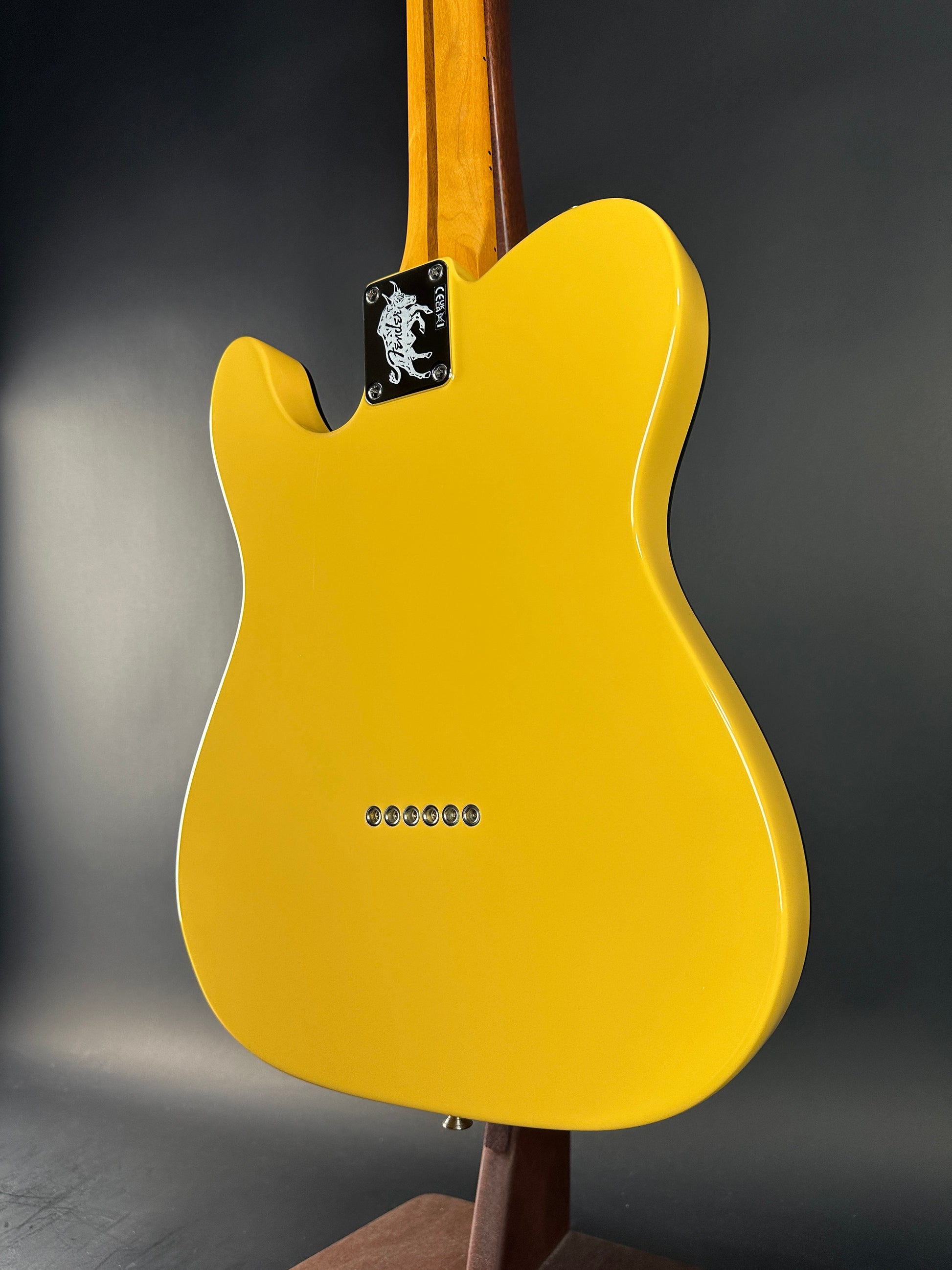 Yellow electric guitar on a dark gray background