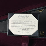 A framed Certificate of Authenticity for a Martin Custom Shop guitar, displayed inside an open black case with a burgundy velvet interior. The certificate is printed on white paper with black text and a circular Martin Custom Shop seal.