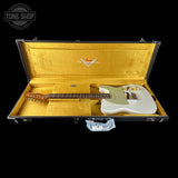 A white Fender electric guitar resting inside an open black hard case with a gold padded interior, shown against a black background. A Tone Shop watermark is visible in the top-left corner.