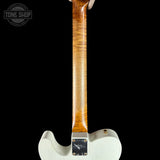 Close-up back view of an electric guitar showing the white body, maple neck, and backplate hardware against a black background.