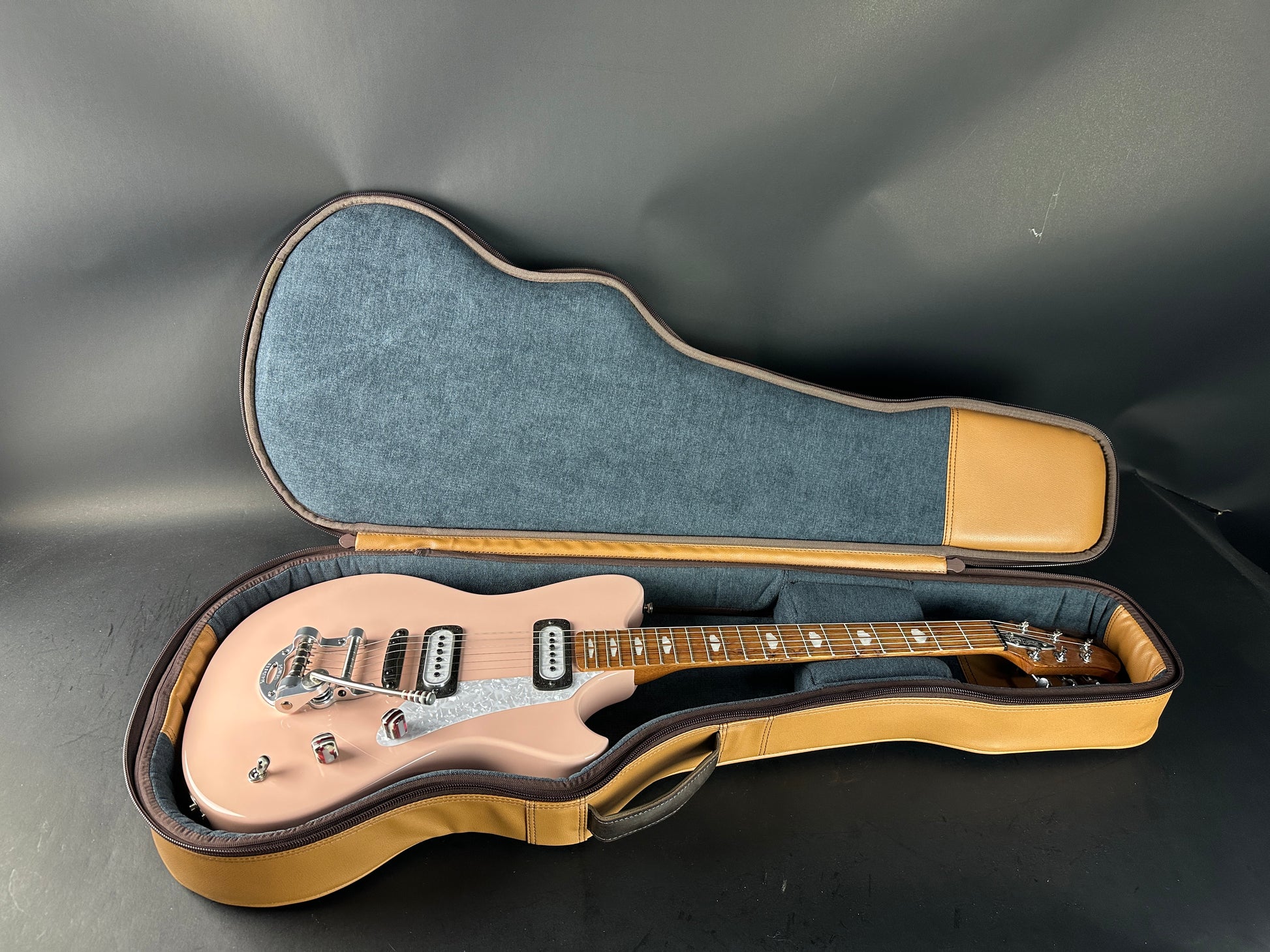 Electric guitar in a hard-shell case on a gray background