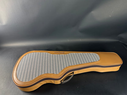Guitar case with checkered interior on a dark background