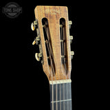 Close-up of the headstock of a Martin & Guarnieri classical guitar, showing the six tuning pegs, strings, and the engraved brand name on a black background.