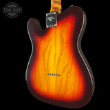 The back of a sunburst electric guitar, showing the wood grain finish fading from bright yellow-orange to dark brown, photographed against a solid black background.