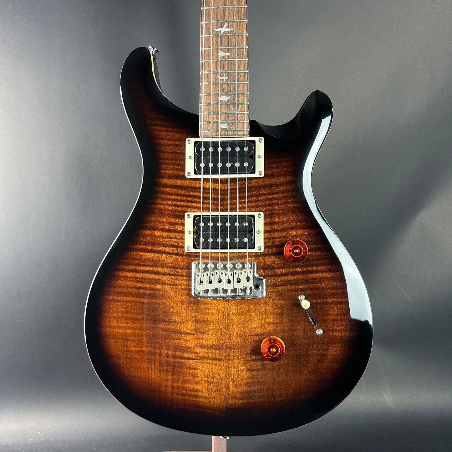 Electric guitar with a sunburst finish on a gray background