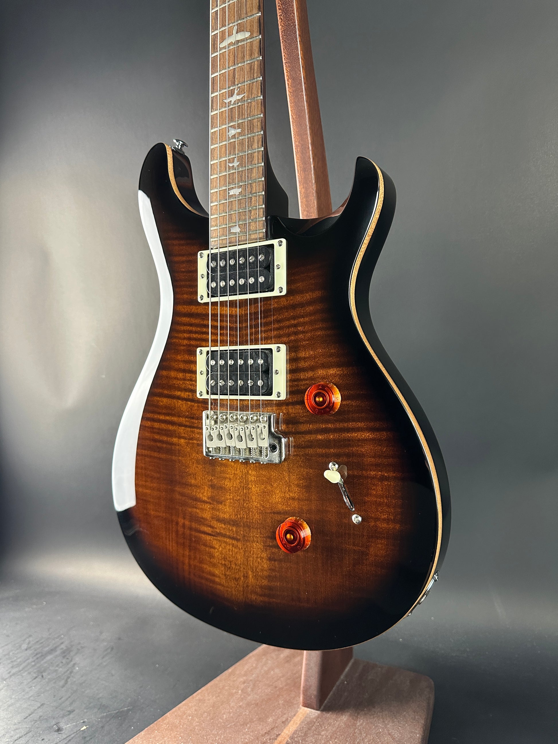 Electric guitar with a wooden finish on a gray surface