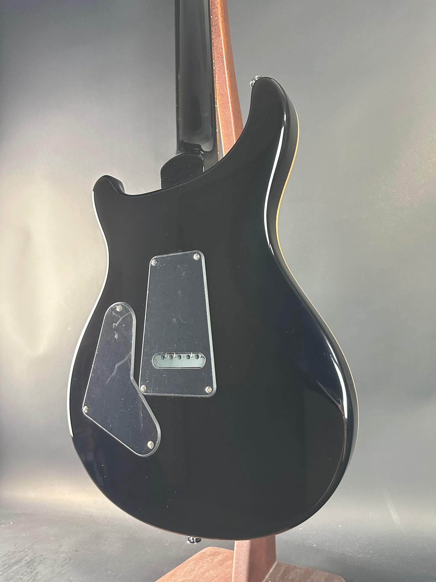 Black electric guitar body on a gray background