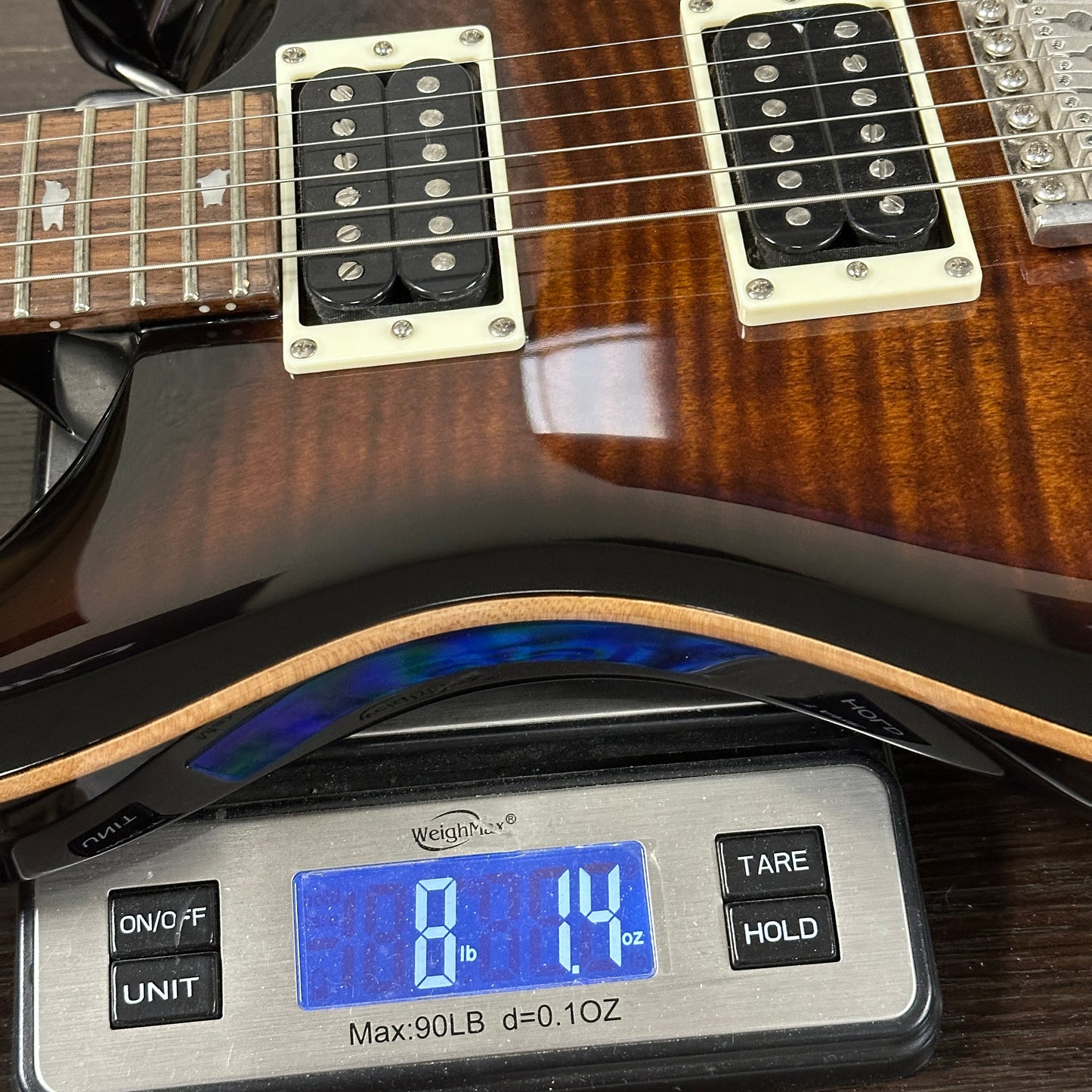 Guitar on a digital scale displaying weight