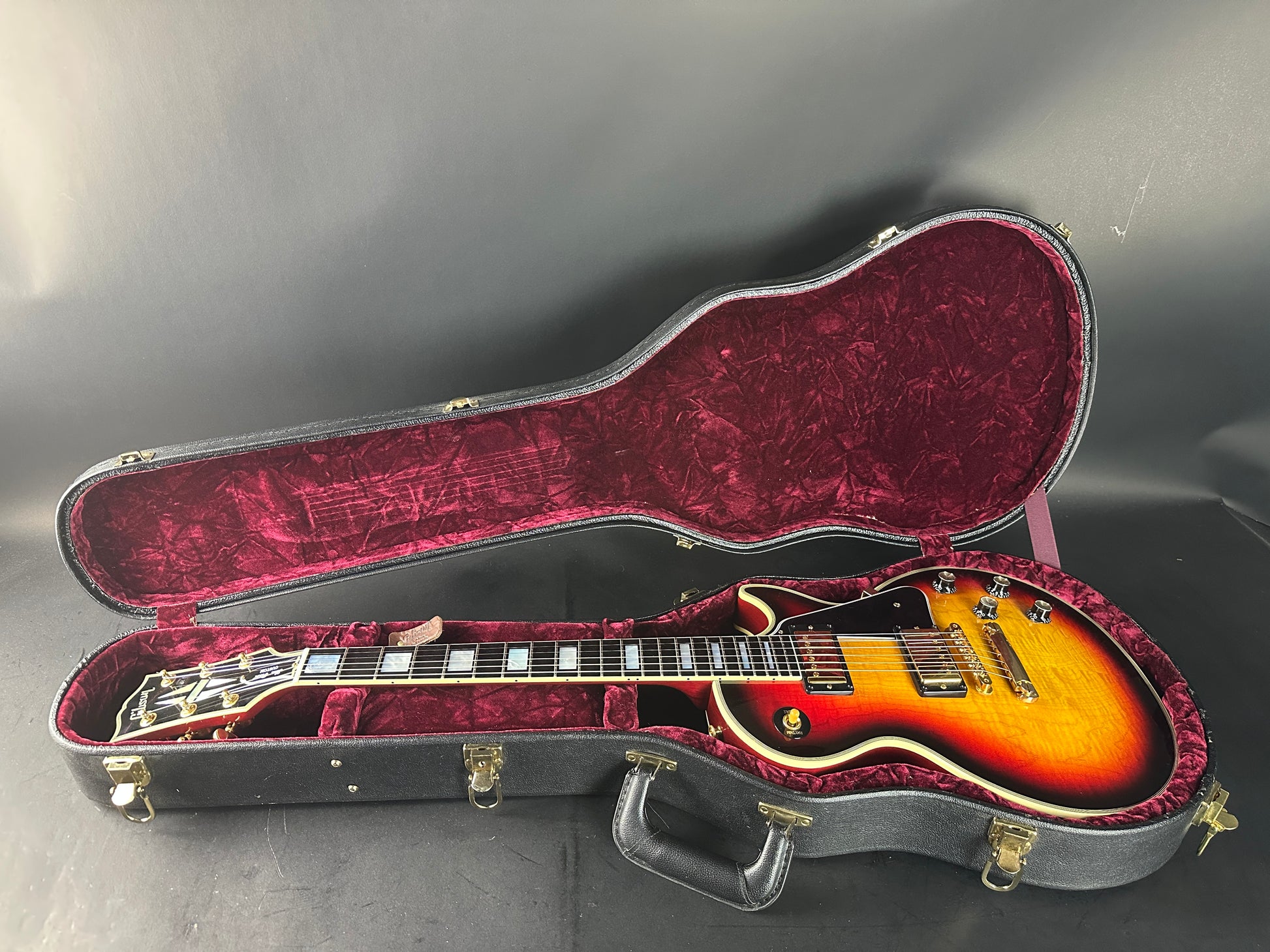 Electric guitar in an open case on a gray surface