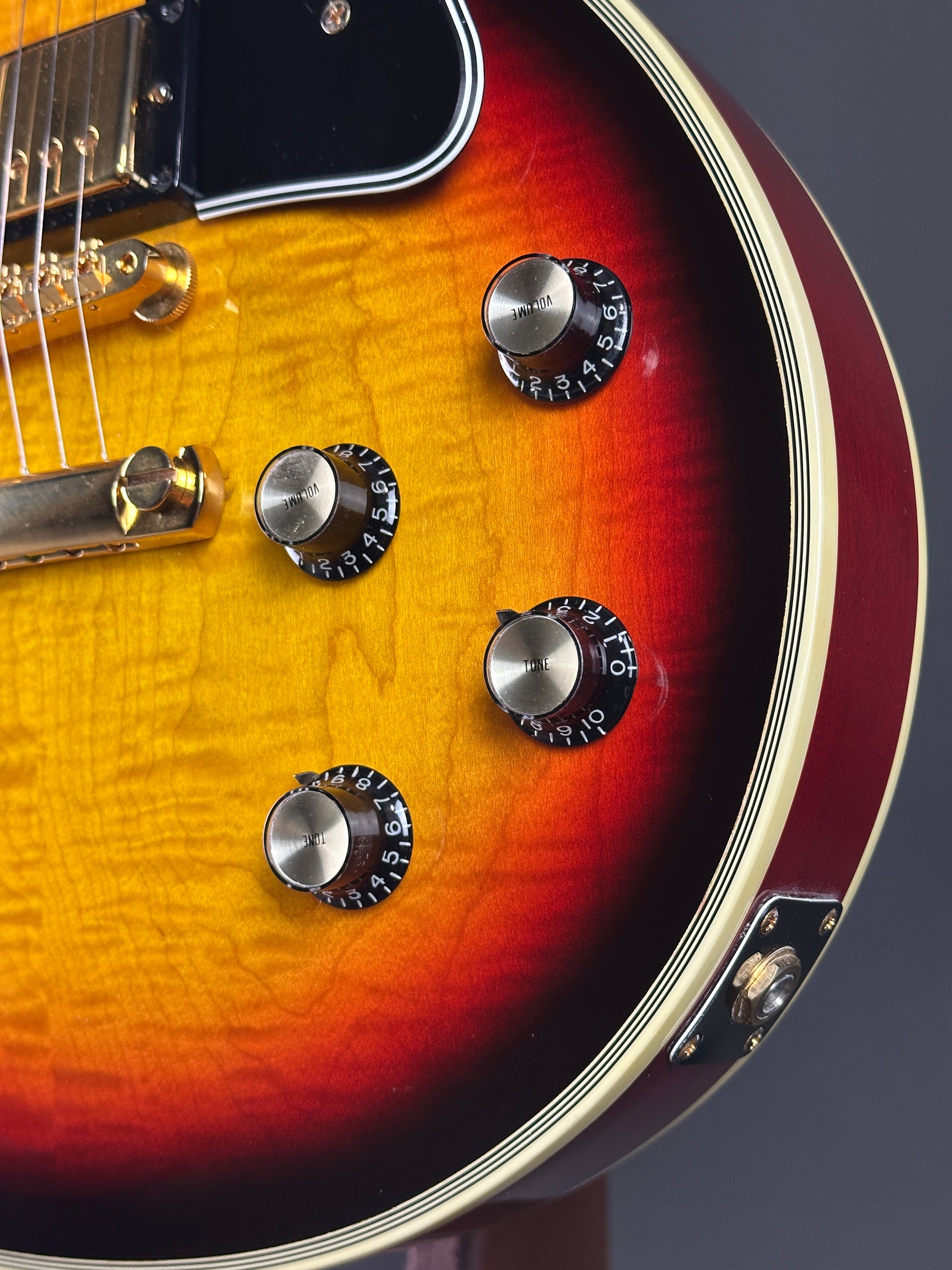 Close-up of a guitar's control knobs with a gradient finish.