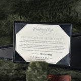A Martin Custom Shop Certificate of Authenticity card displayed inside a black presentation box, set against a dark green faux fur background.