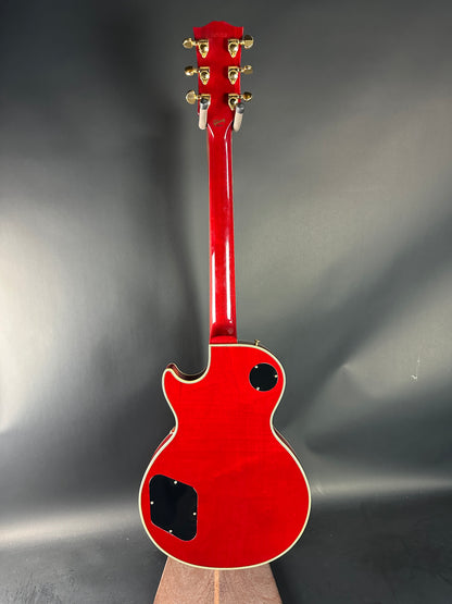 Red electric guitar headstock on a gray background