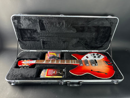 Red electric guitar in an open hard-shell case on a gray background