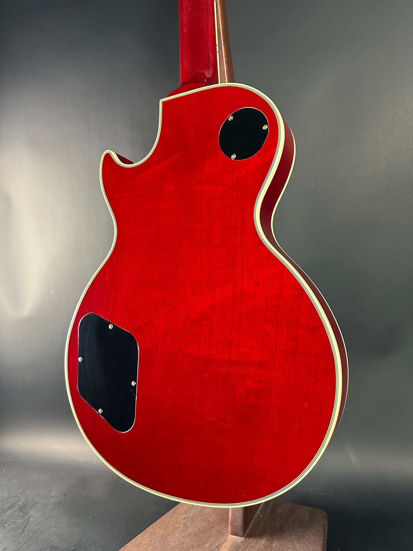 Red electric guitar body on a gray background