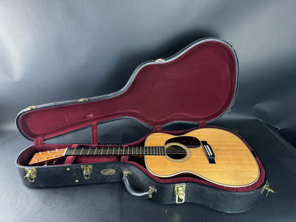 Acoustic guitar in an open case on a gray background