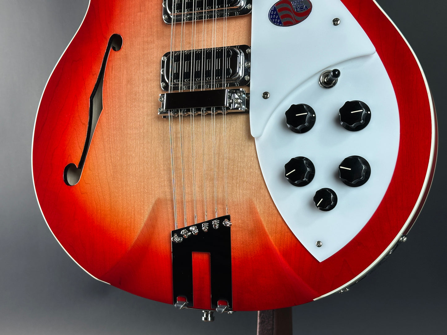 Close-up of a red and white electric guitar on a gray background