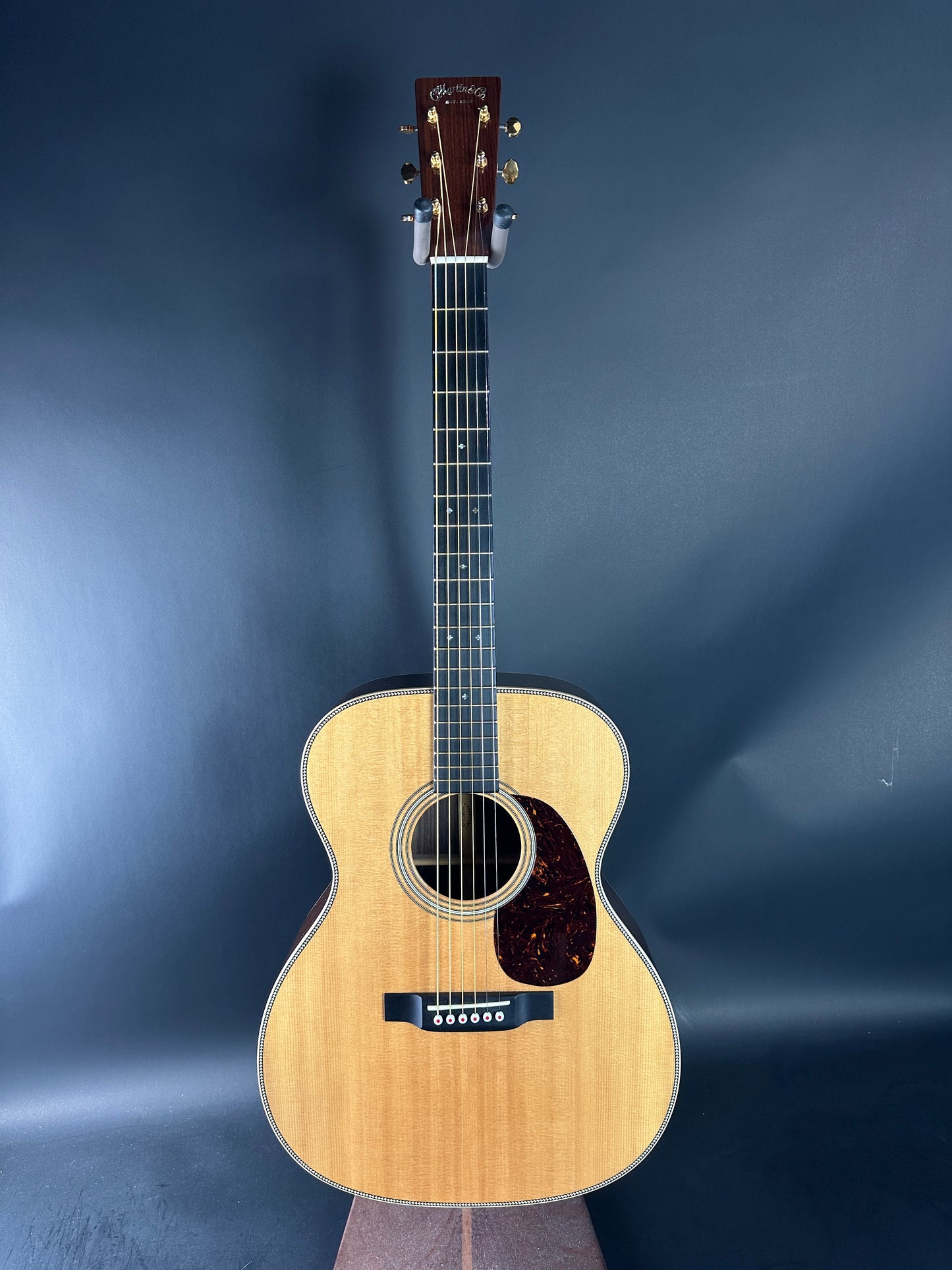 Acoustic guitar on a reflective blue surface