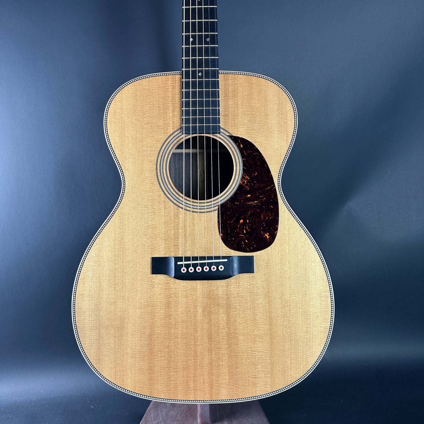 Acoustic guitar with a wooden finish on a dark blue background