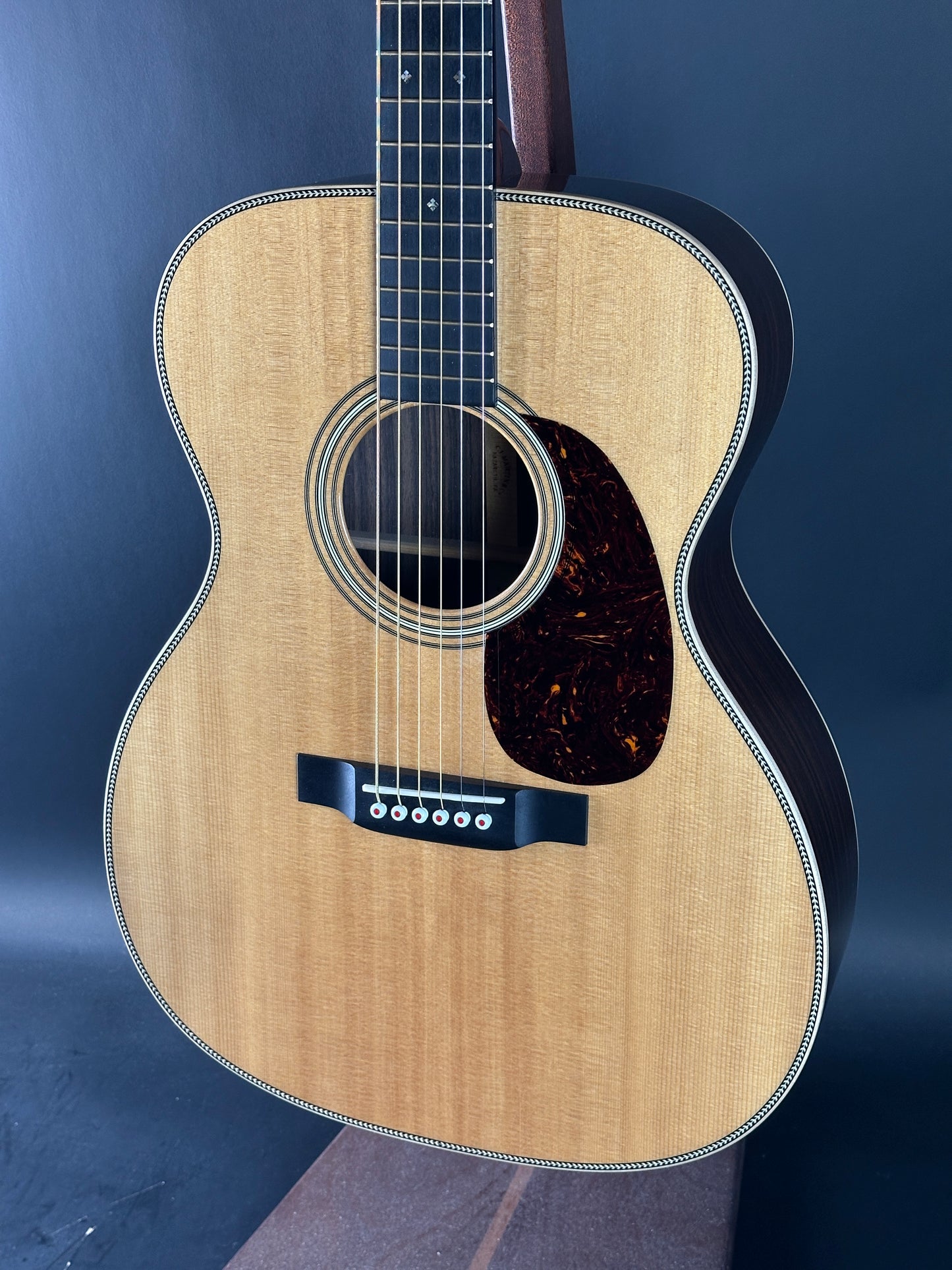 Acoustic guitar with a visible brand logo on a dark background