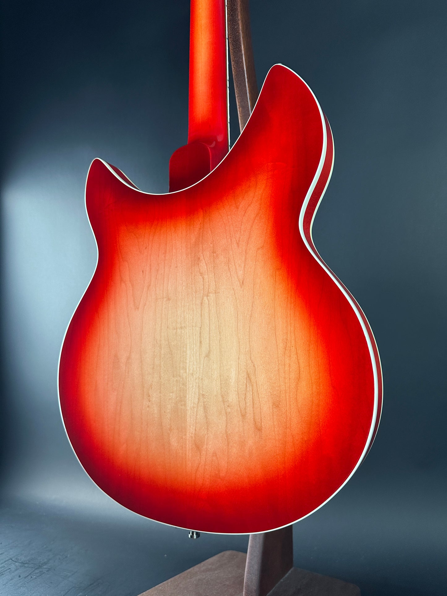 Close-up of a red electric guitar body on a dark background