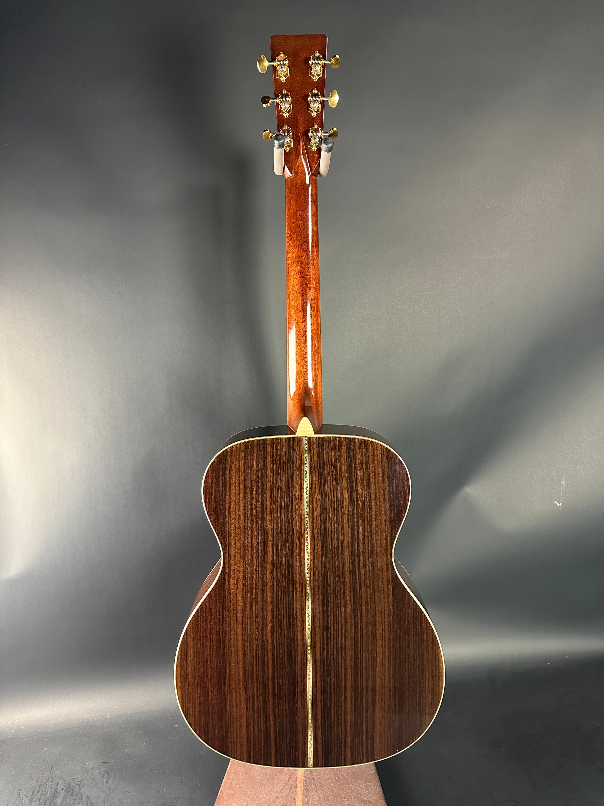 Wooden acoustic guitar on a reflective gray surface