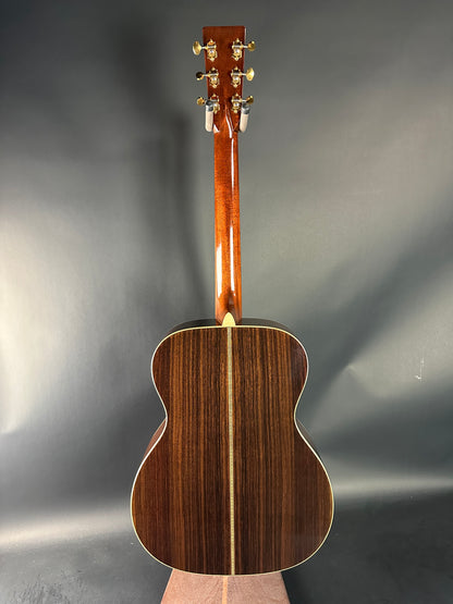 Wooden acoustic guitar on a reflective gray surface