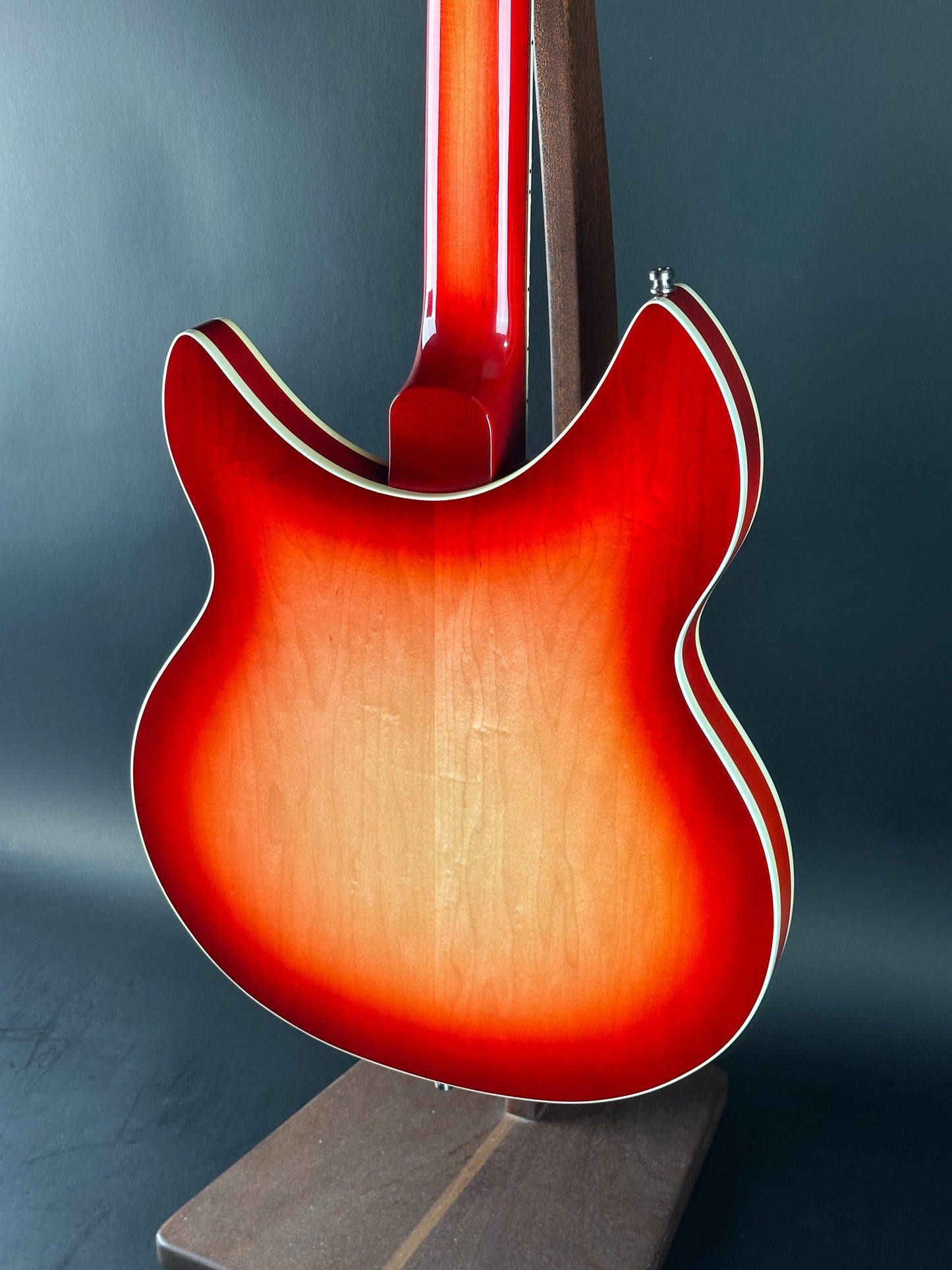 Close-up of a red electric guitar on a dark background