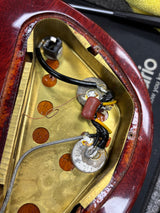 Close-up of a guitar pickup with visible wiring and components.
