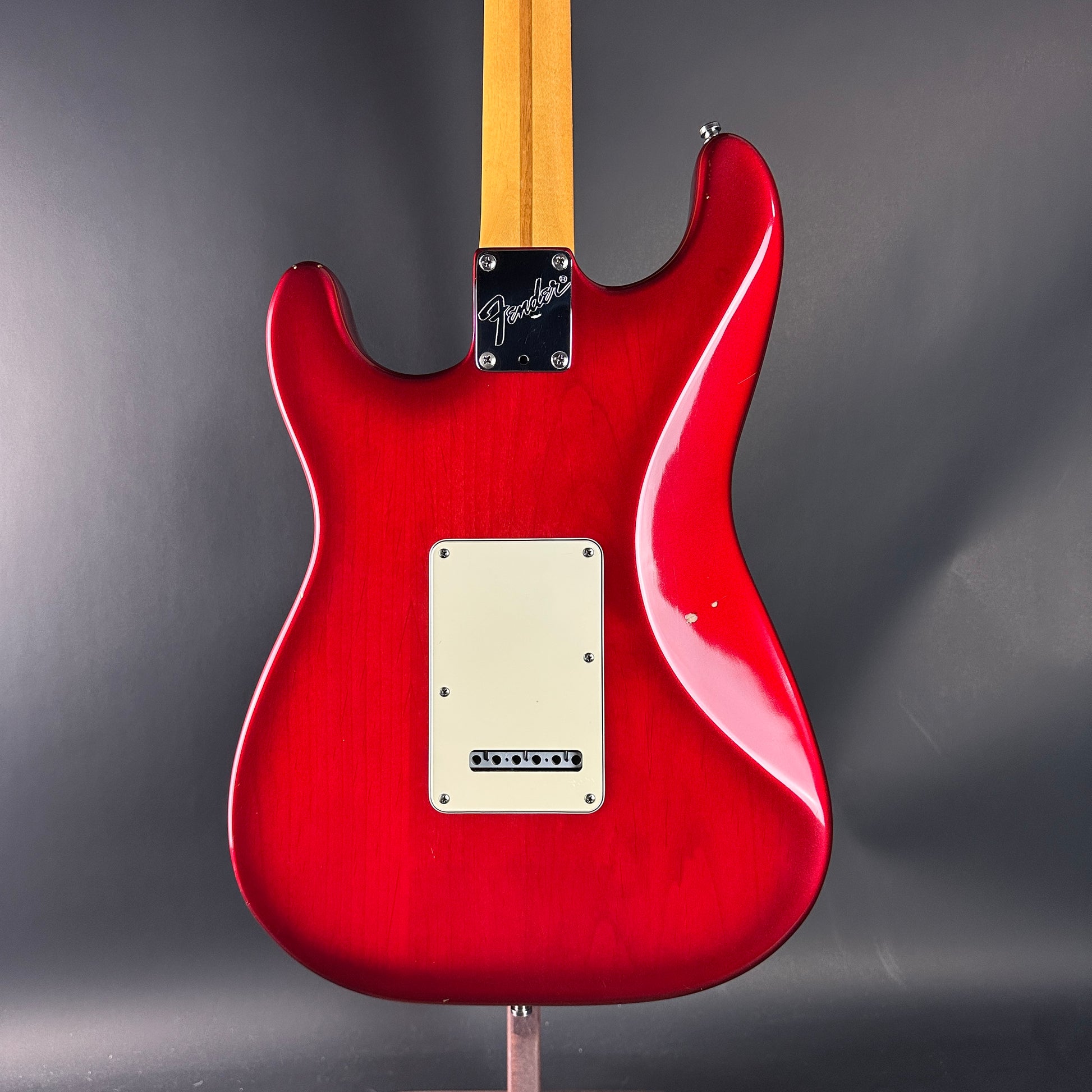 Red electric guitar with Fender logo on a gray background