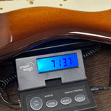 Used 2015 Fender Custom Shop Artisan Okoume Strat on scale displaying weight.