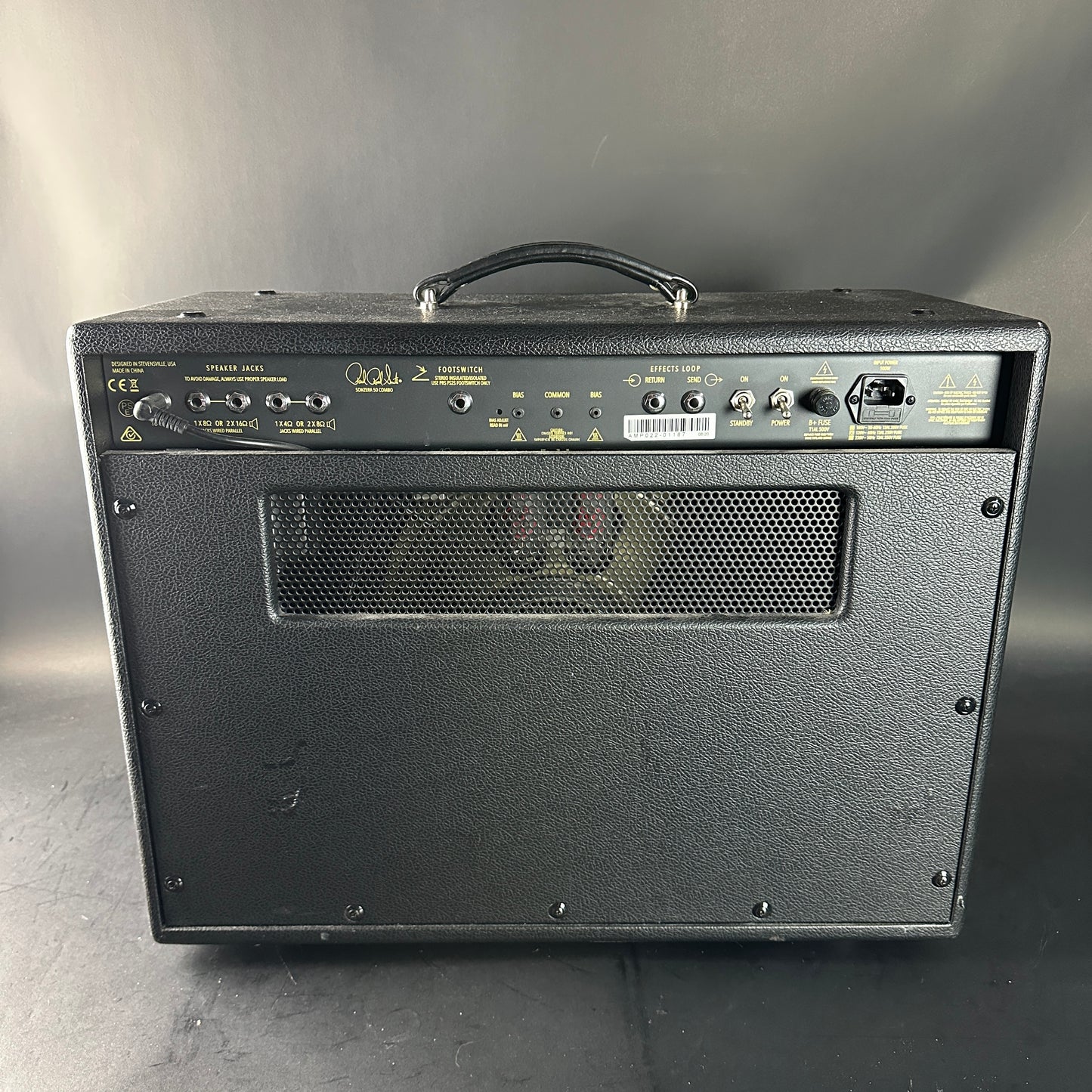 Black guitar amplifier with visible brand logo on a gray background