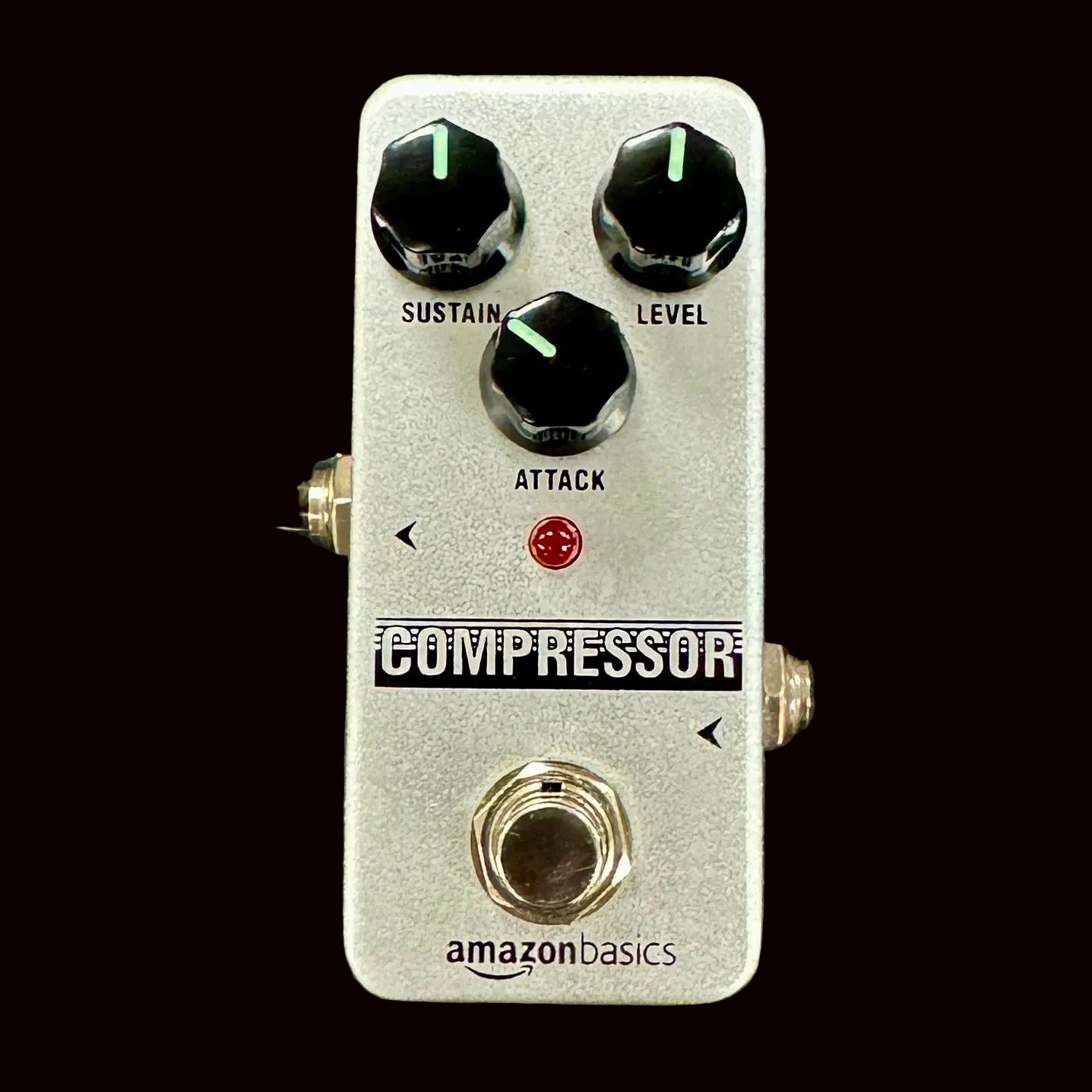 Guitar effects pedal labeled 'Compressor' with three knobs on a textured surface