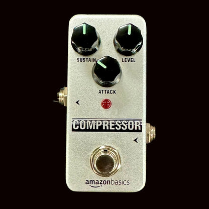 Guitar effects pedal labeled 'Compressor' with three knobs on a textured surface