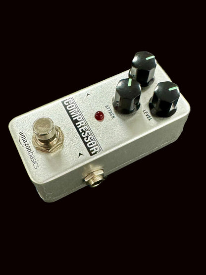 Guitar effects pedal labeled 'Compressor' on a textured surface