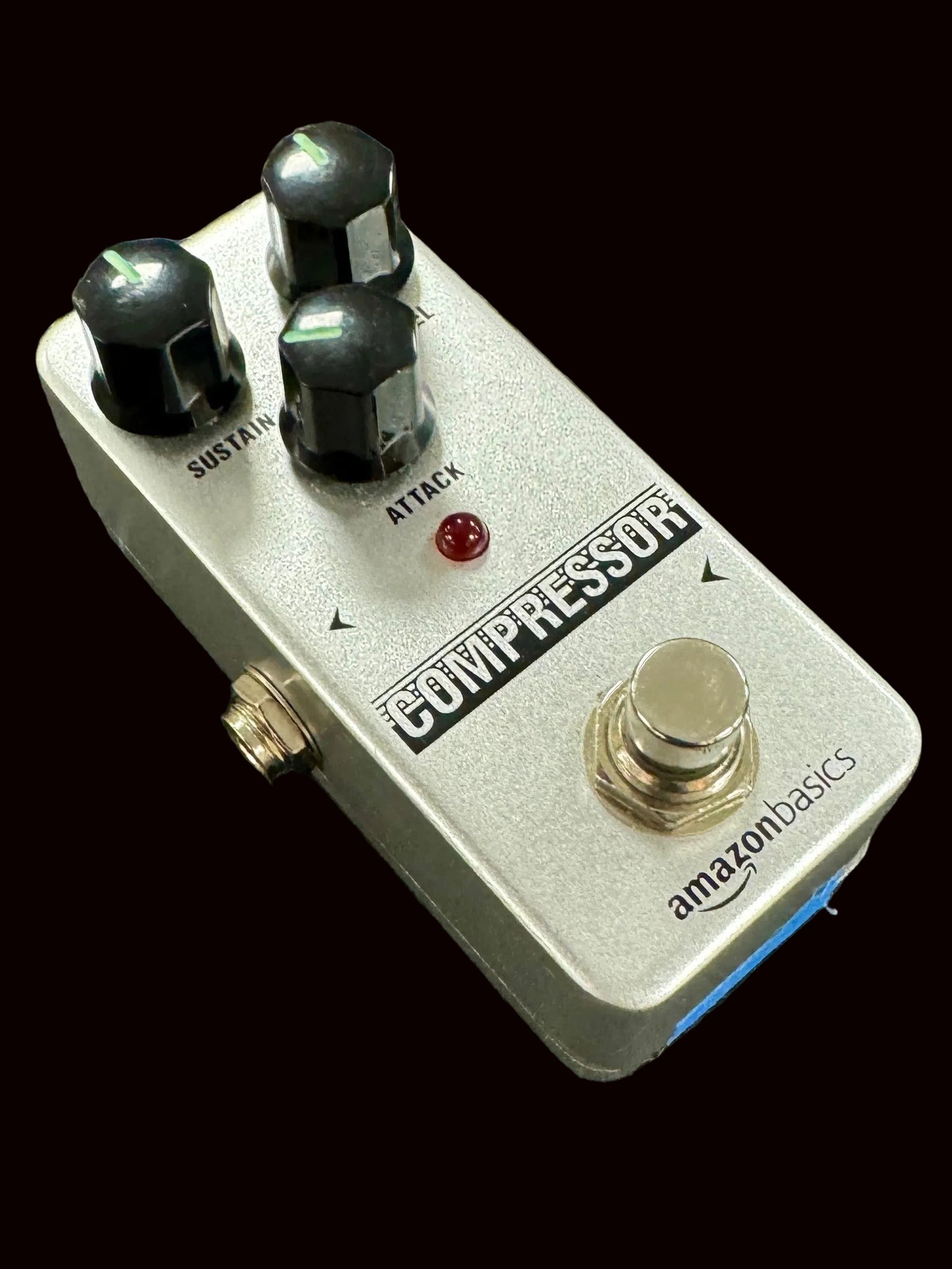 Compressor guitar effects pedal with 'AmazonBasics' branding on a textured surface
