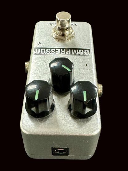 Guitar effects pedal with three knobs on a textured surface