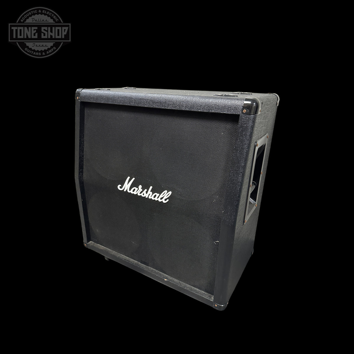 A vintage Marshall guitar amplifier cabinet in black textured fabric with the white Marshall logo on the front, shown at an angle against a black background with a Tone Shop watermark in the top left.