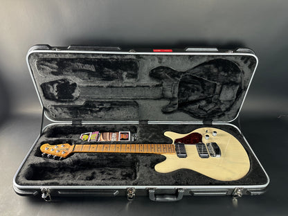 Electric guitar in an open hard-shell case on a gray background