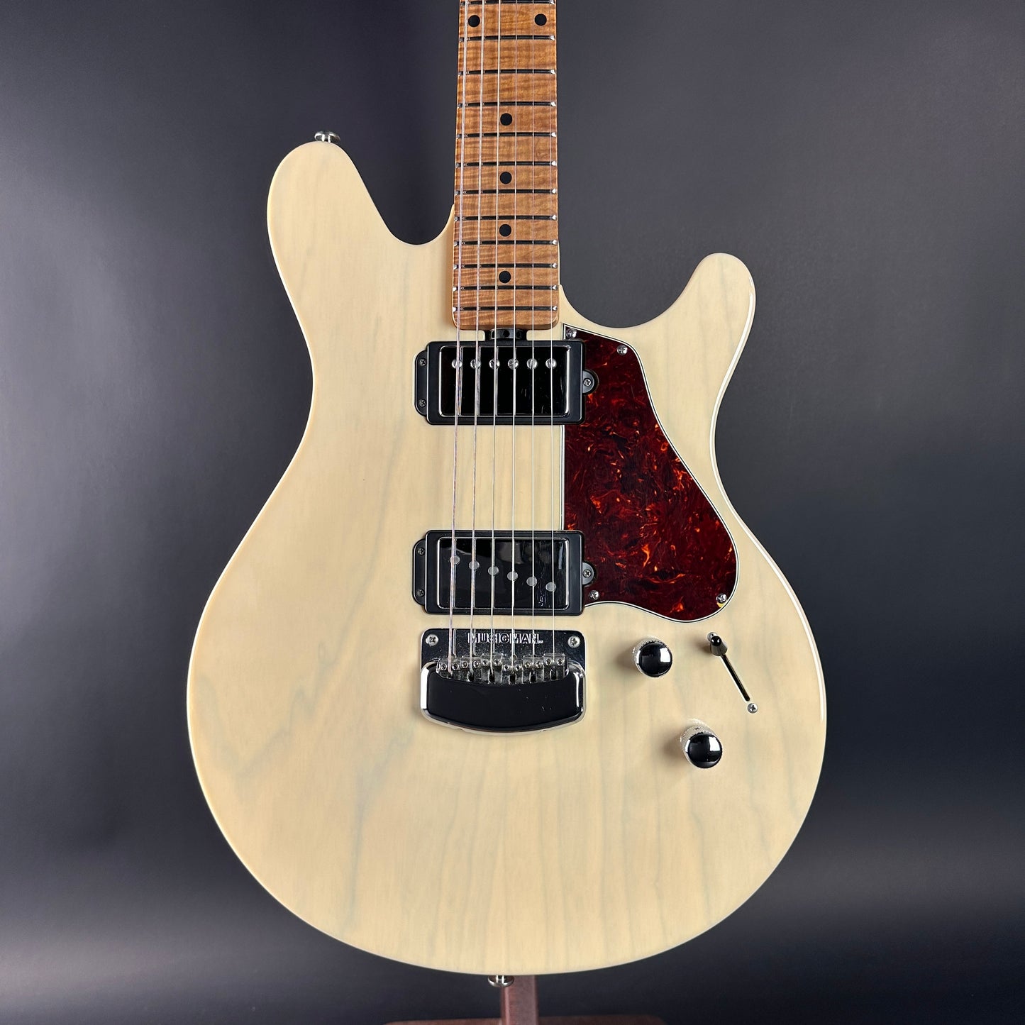Electric guitar with a wooden body and neck on a dark background