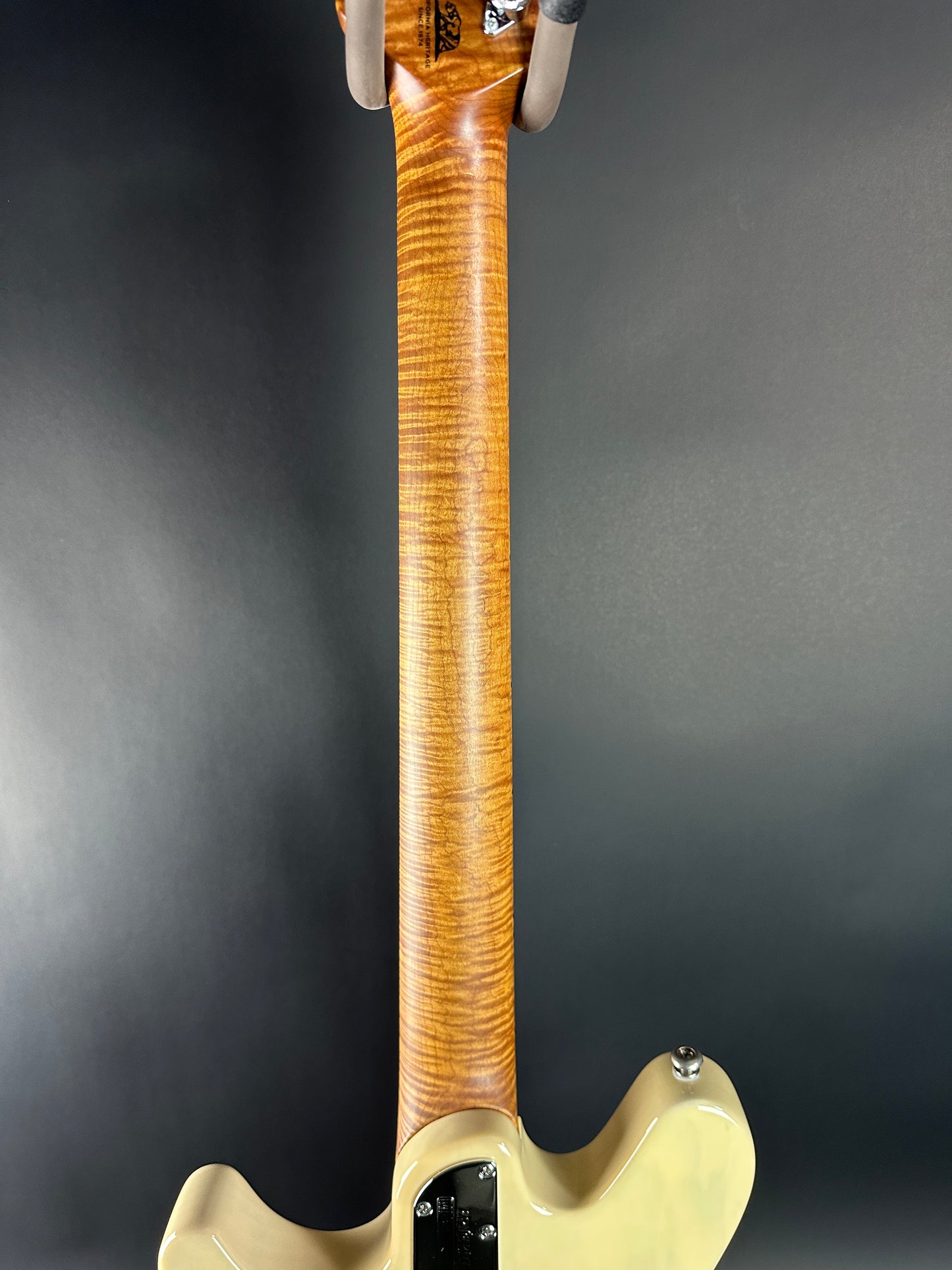 Close-up of a guitar neck and body on a dark background