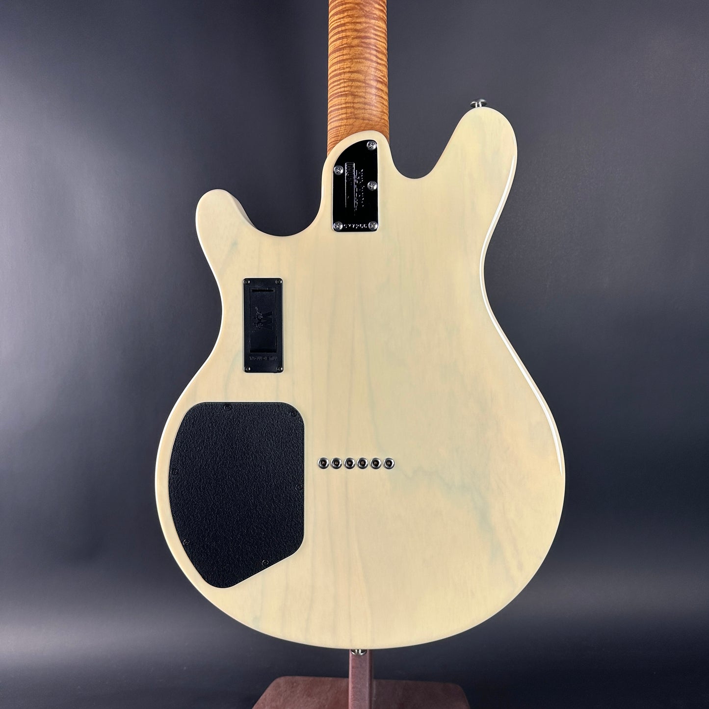 Electric guitar with a wooden neck on a dark gray background