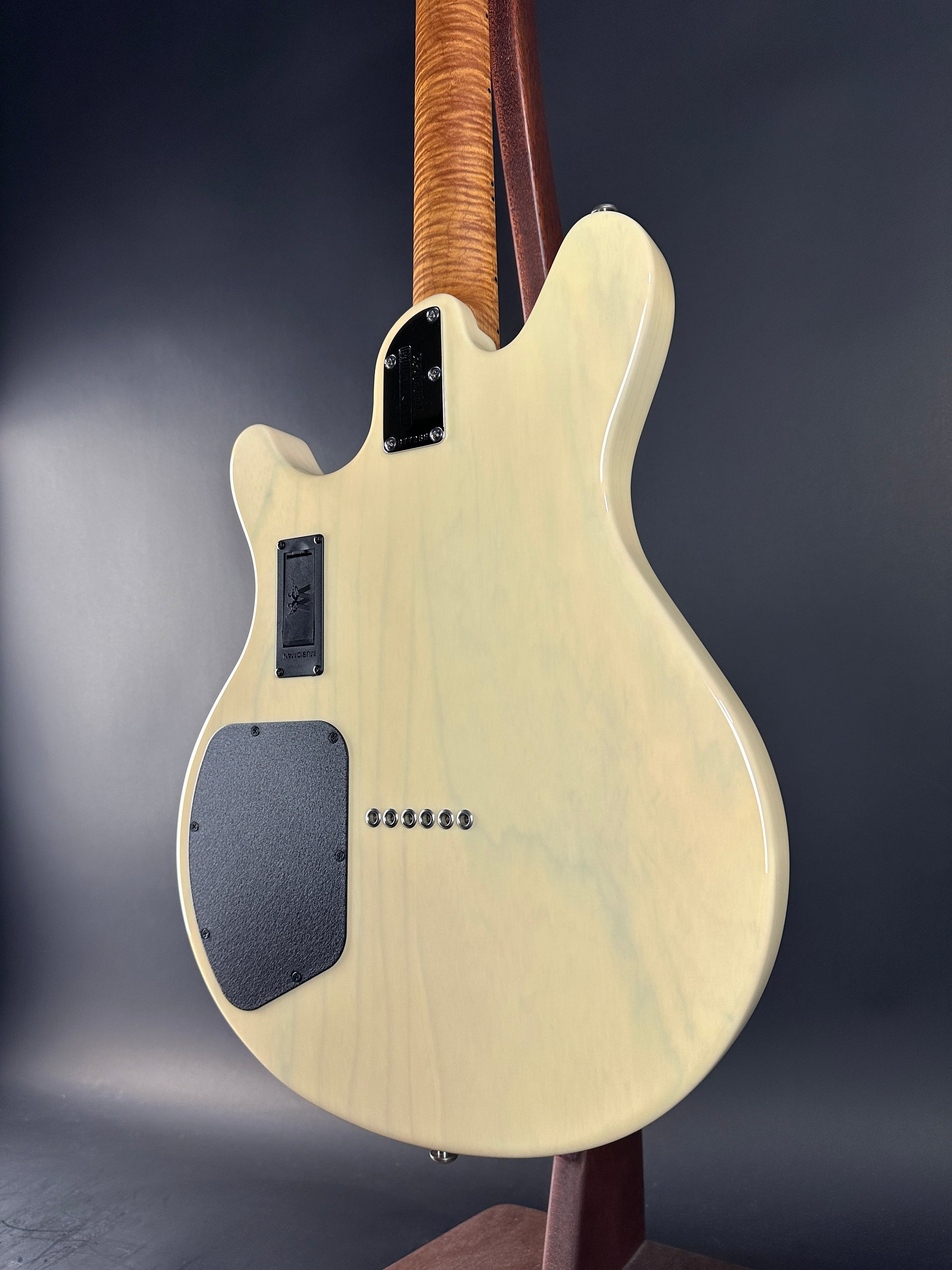 Back view of a white electric guitar with a dark gray pickguard on a gradient gray background