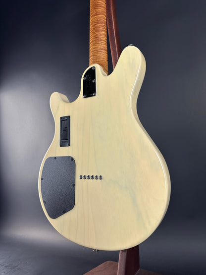Back view of a white electric guitar with a dark gray pickguard on a gradient gray background