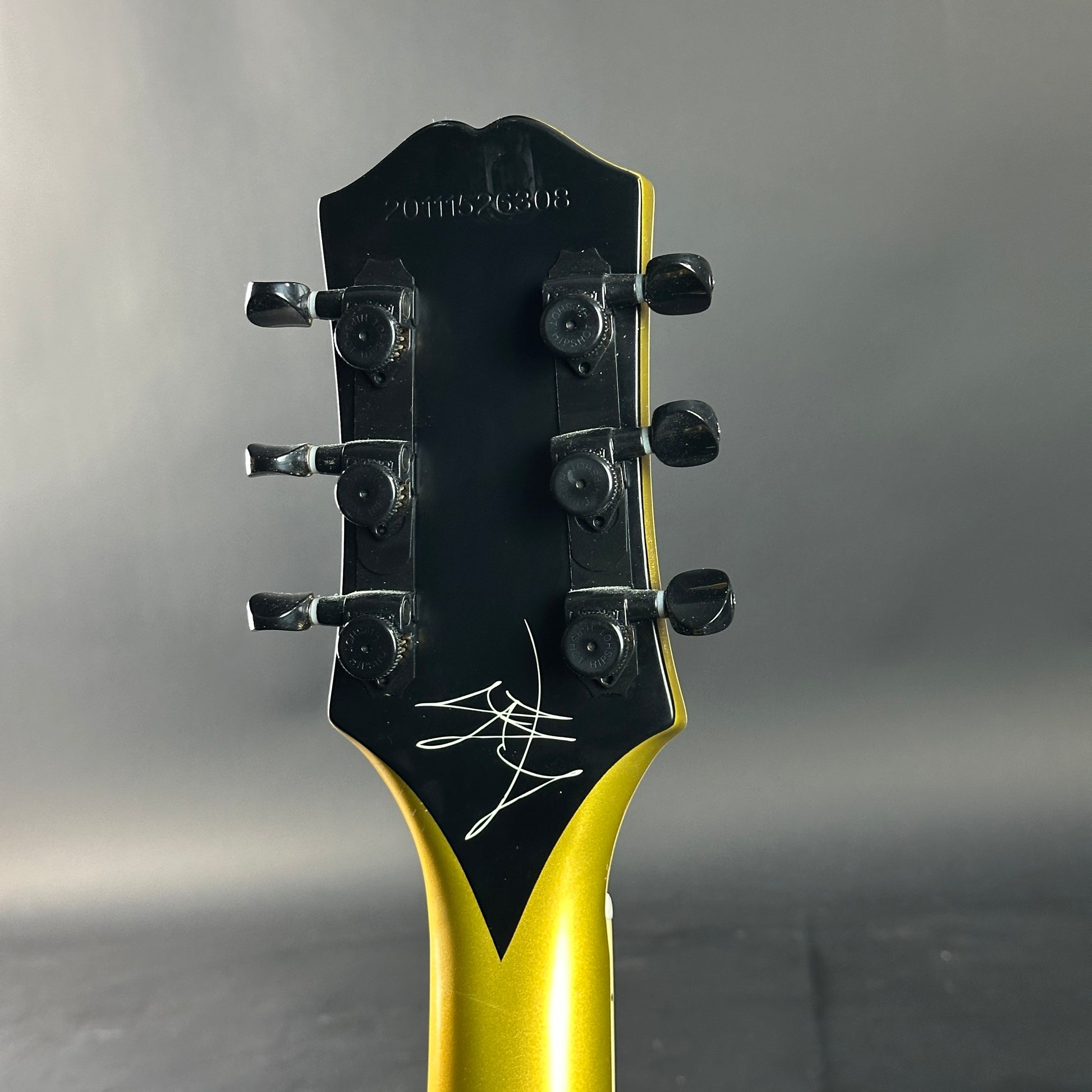 Guitar headstock with black and yellow design on a gray background