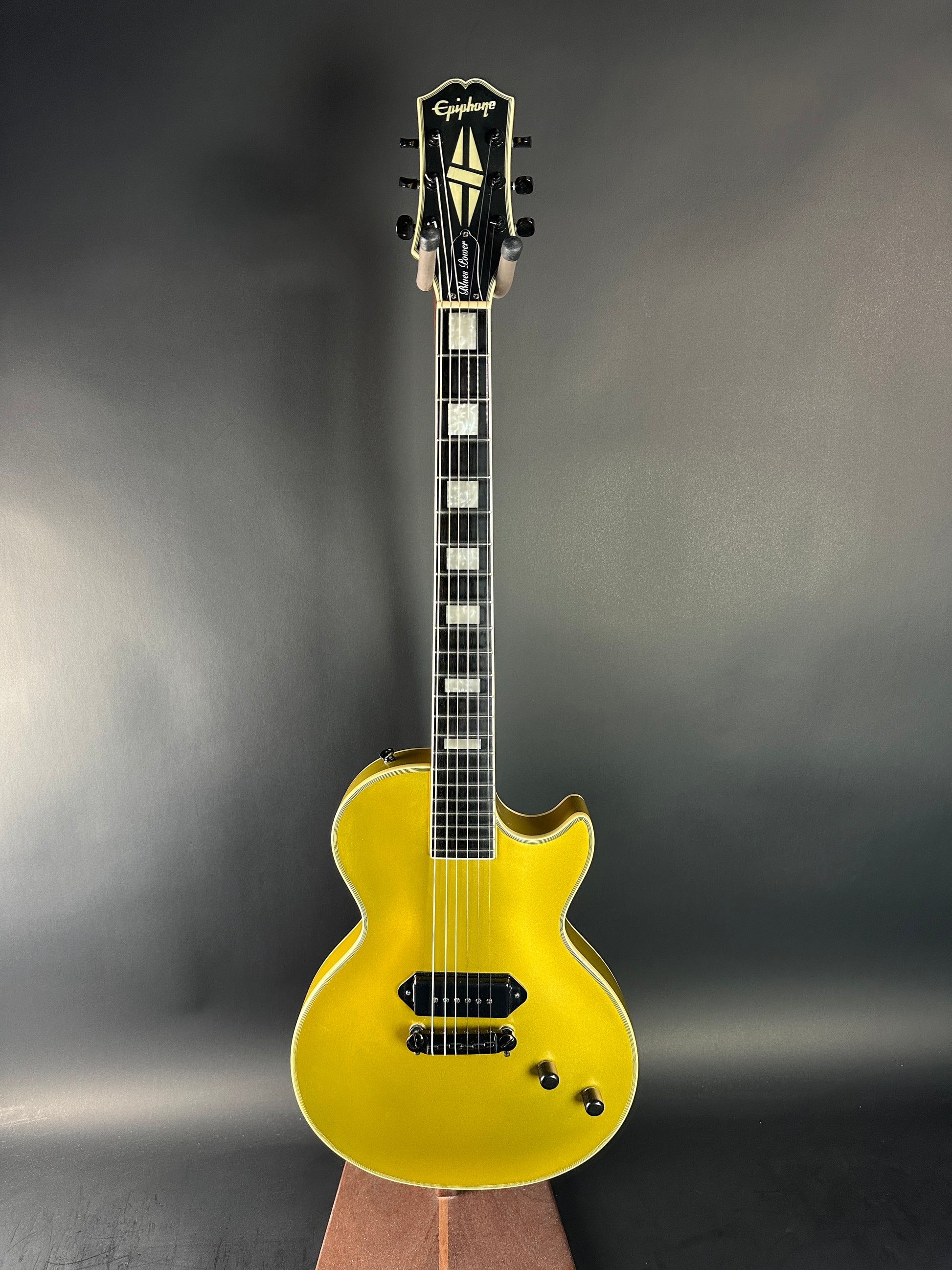 Yellow electric guitar on a dark gray background